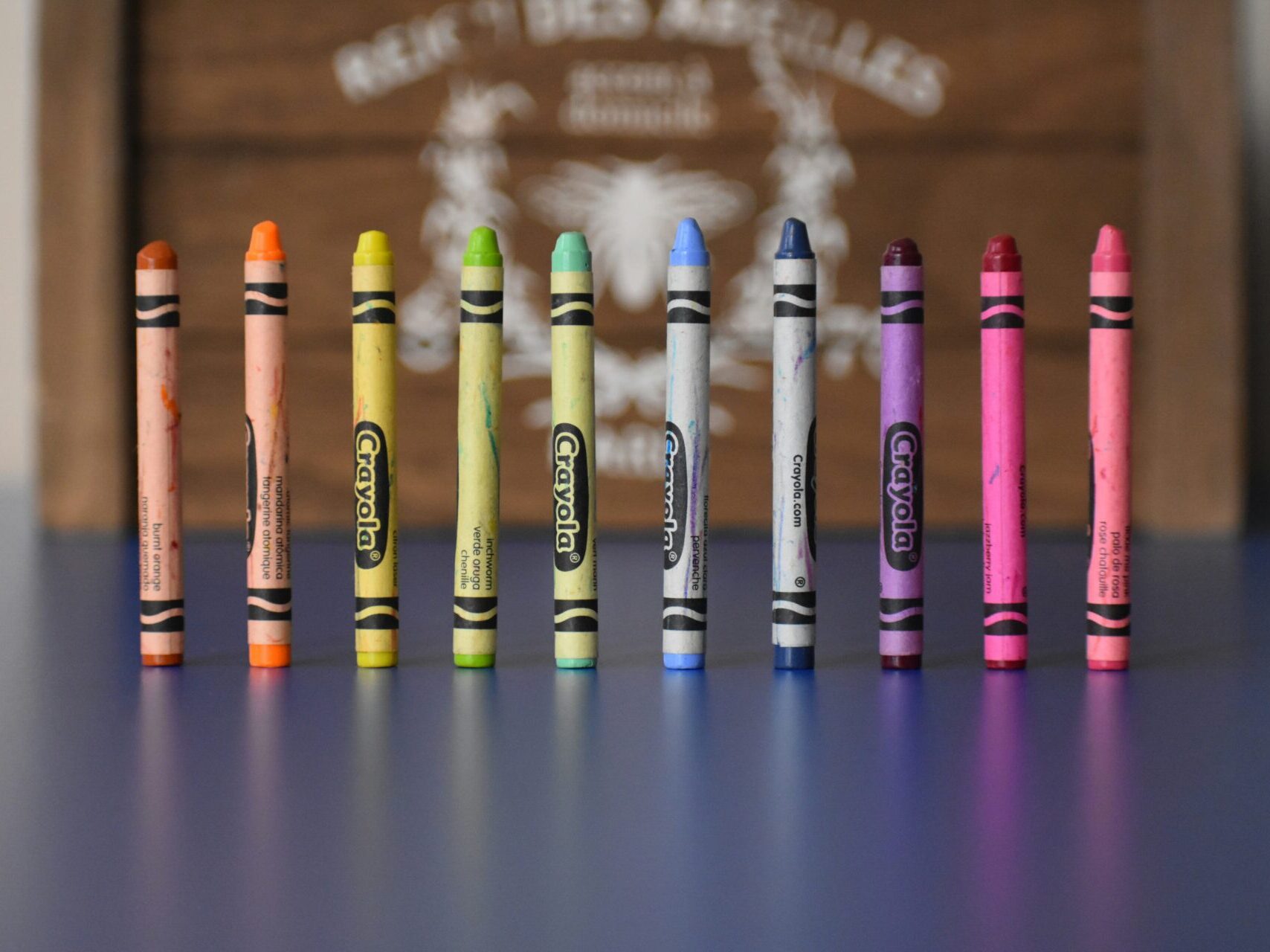 different colors of crayons standing upright on a table with blurred background