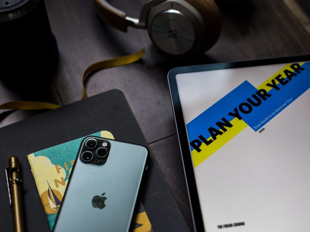 items on desk including phone tablet and paper that reads "Plan Your Year"