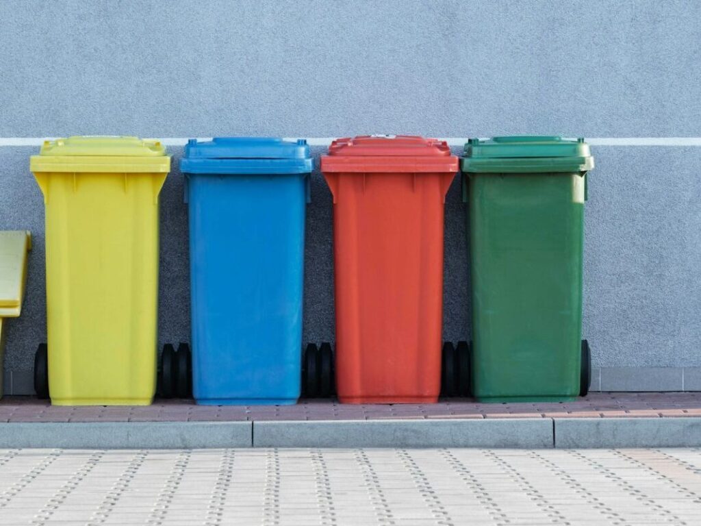 row of colorful trashbins against a gray wall