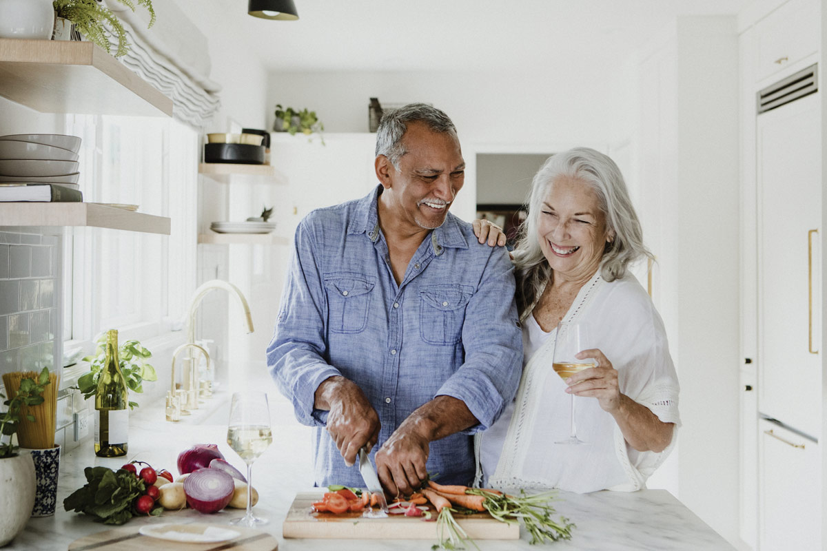 Department Image: RETIRE. Older couple cooking together in kitchen