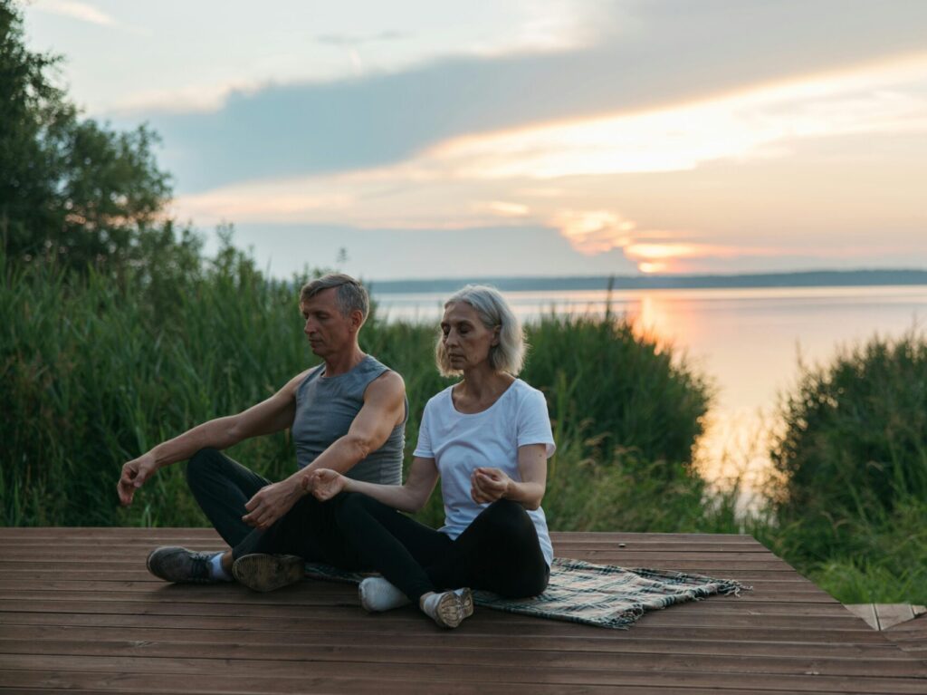 could meditating on a blanket on an outdoor deck near lake