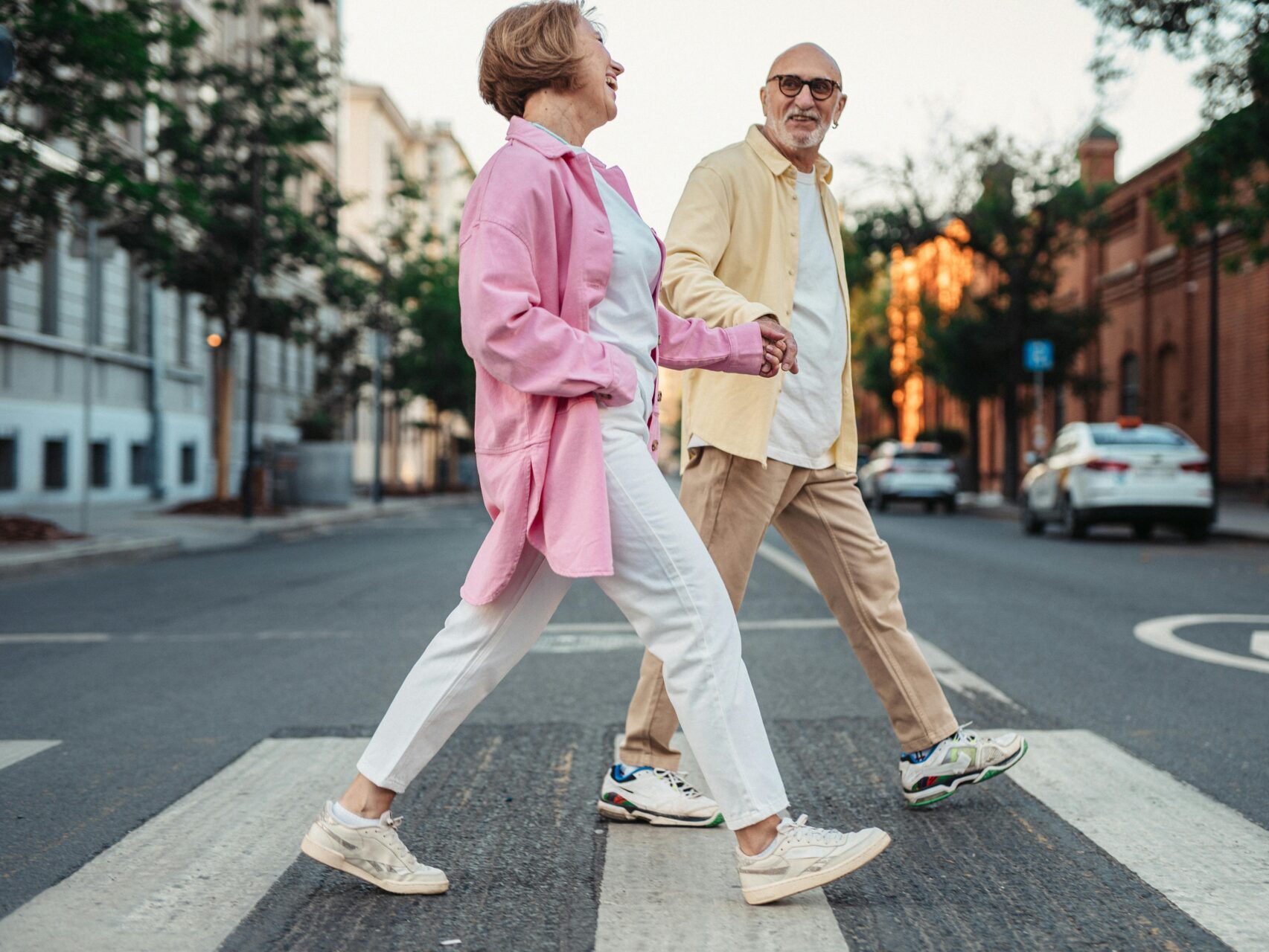 two older adults walking across a crosswalk