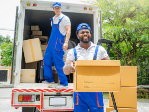 Professional movers moving boxes out of moving truck.