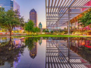 Downtown Dallas with part of city reflecting in water.