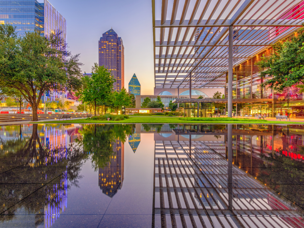 Downtown Dallas with part of city reflecting in water.