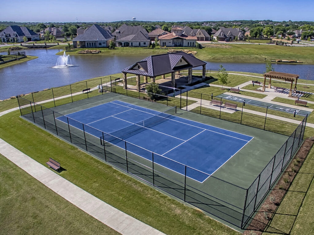 Arial view of tennis court, lake and houses at Watermere at Southlake 55+ active adult community for article 10 Best Active Adult Communities in DFW for newcomers retiring in DFW.