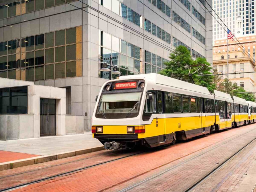 Picture of yellow and white public transportation in Dallas for article Insider Guide to Riding DART from the Airport in the Dallas-Fort Worth Area for newcomers moving to DFW.