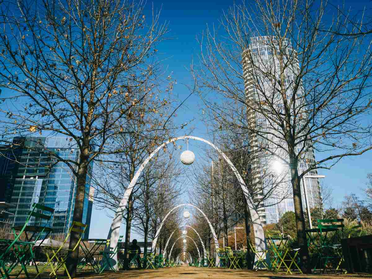 Picture of Klyde Warren Park with arches with balls hanging from the top center of the arch going down the walkway for people to walk under for article 5 Fun Weekend Activities in Dallas for newcomers moving to DFW.