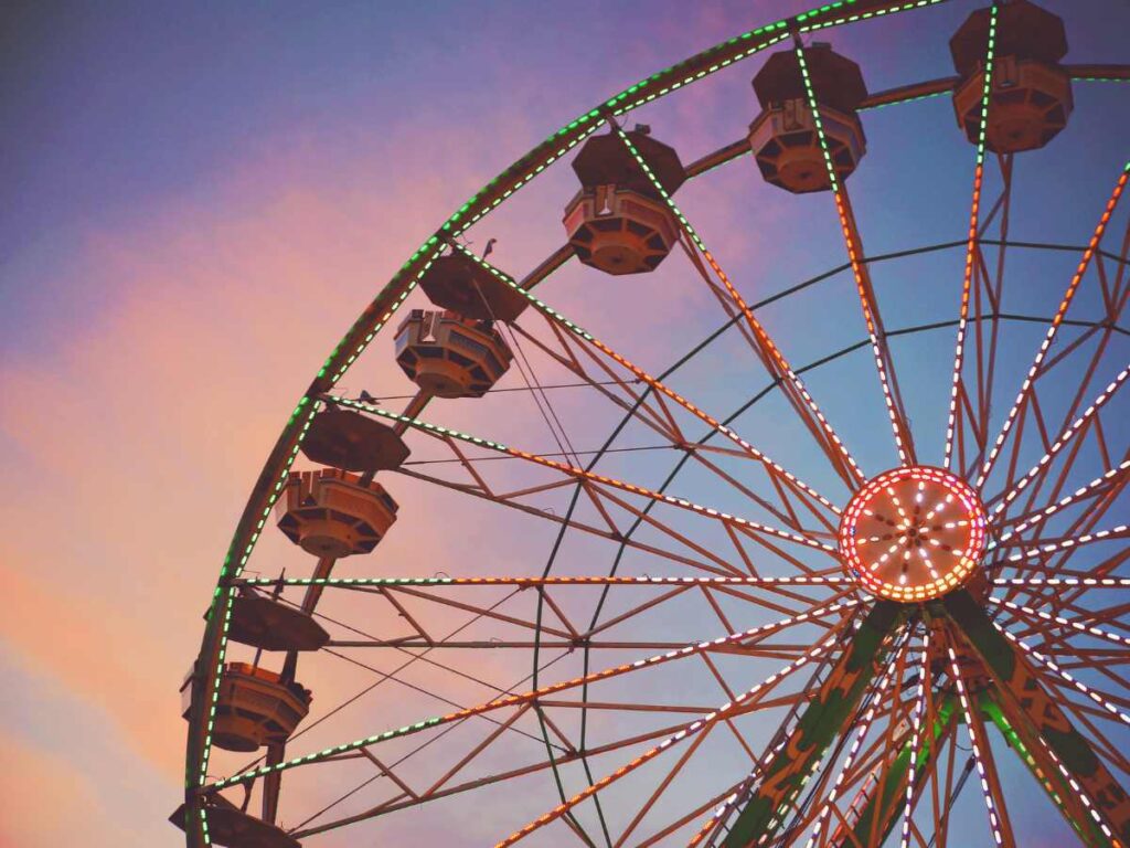 Top of the DFW Ferris Wheel with a pink, purple, and blue sky background for article DFW Annual Events Calendar: 12 Popular Activities for newcomers moving to DFW area.