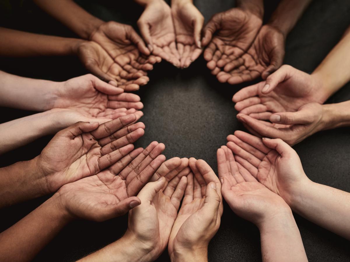 Bunch of hands palms up forming a circle representing reaching out helping hands for article 25 Outstanding Special Needs Resources in DFW for newcomers moving to DFW.