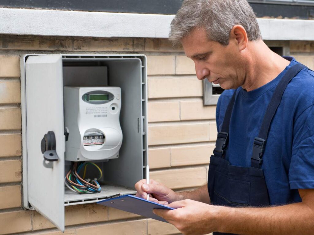 Utility worker in blue overalls working on open home meter box for article Setting Up Utilities in DFW in 2025 for newcomers moving to DFW.