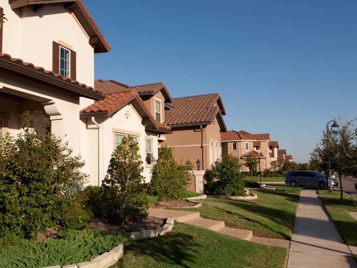 Suburban housing in Dallas showing houses in neighborhood with sidewalk for article Dallas-Fort Worth Affordability Measures Up for newcomers moving to DFW.