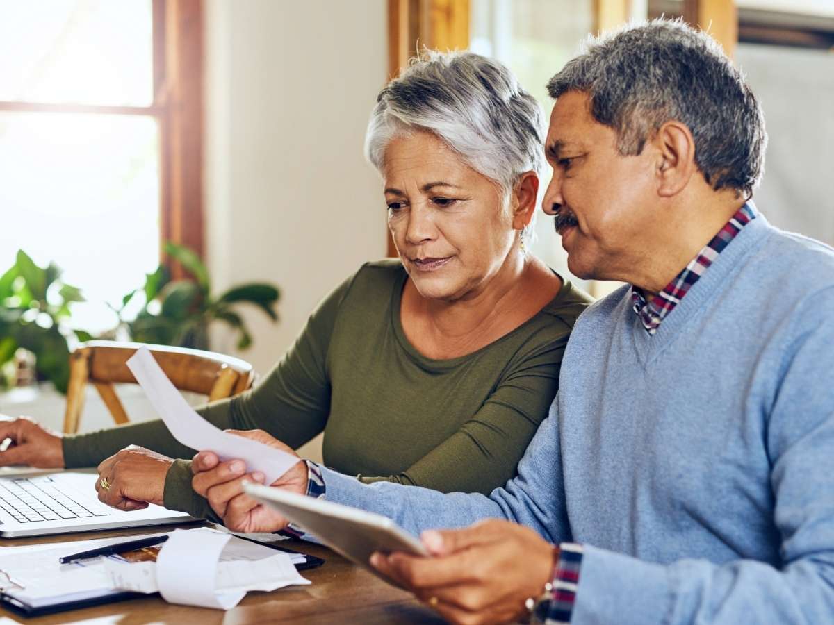 Senior woman and man sitting at table going over lots of papers and notes for article Navigating Retirement Taxes in Texas in 2025 for newcomers moving to DFW.