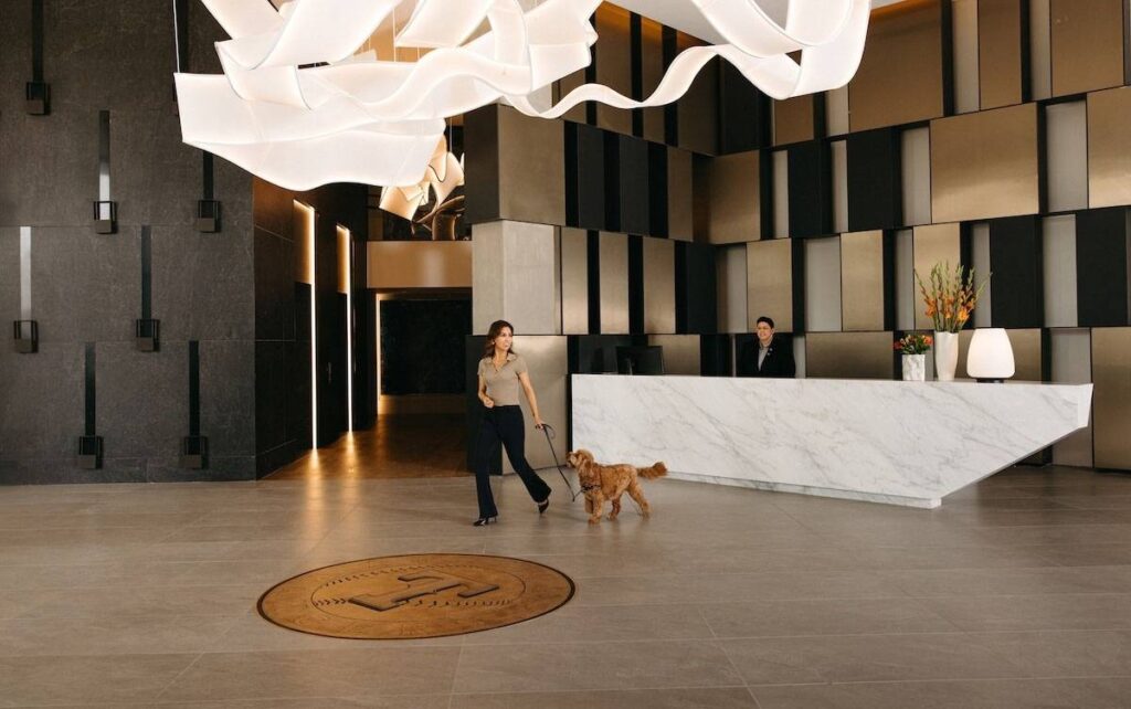 Woman with dog walking away from long counter in grand entrance in One Rangers Way for article The Best Place to Live in DFW Might Be Exactly Between Dallas and Fort Worth for newcomers moving to DFW area.
