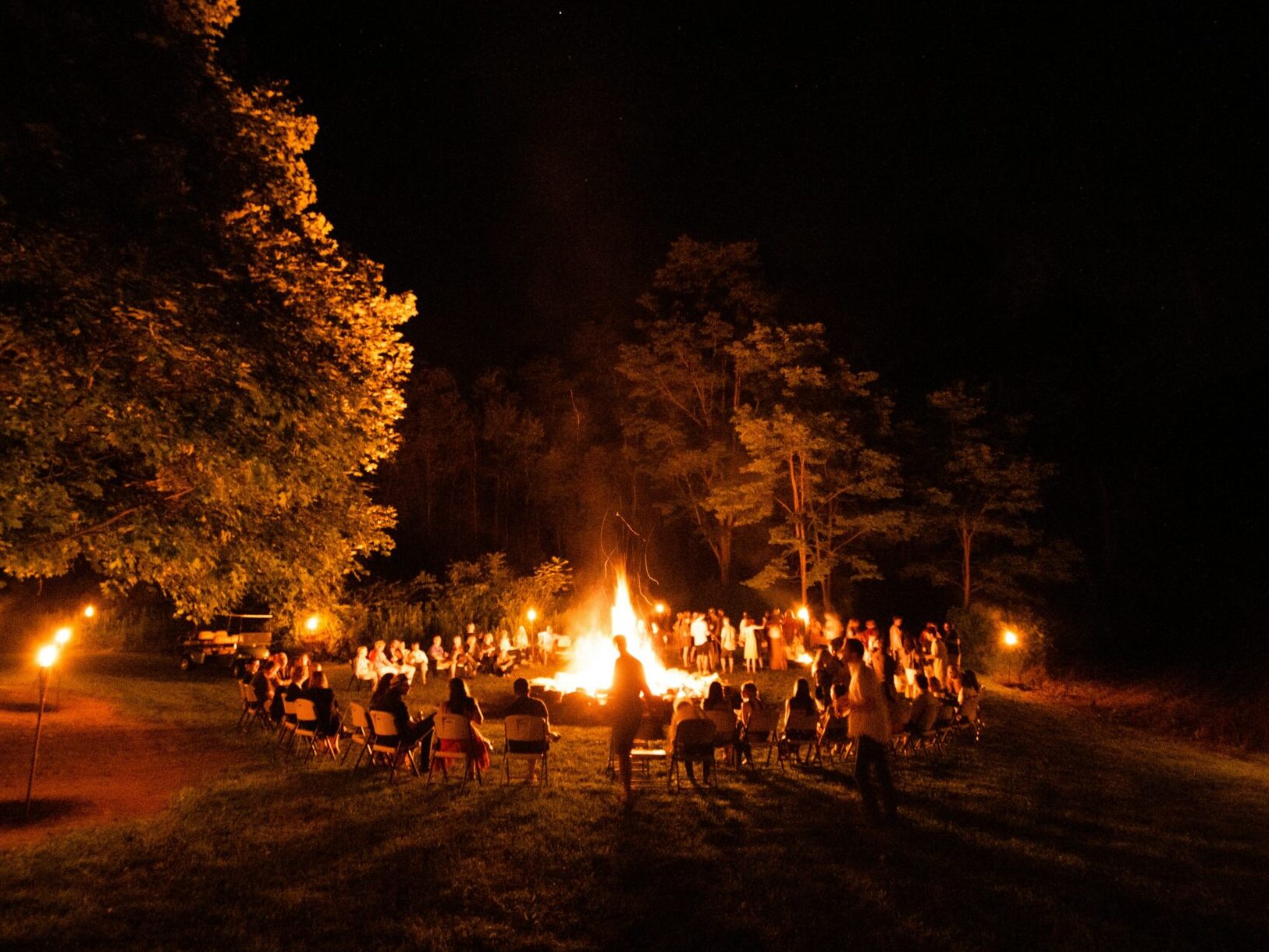 Kids sitting by a large camp fire. Best Summer camps in Dallas